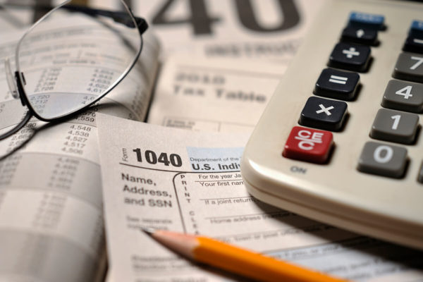 1040 tax form, a calculator, and a pencil